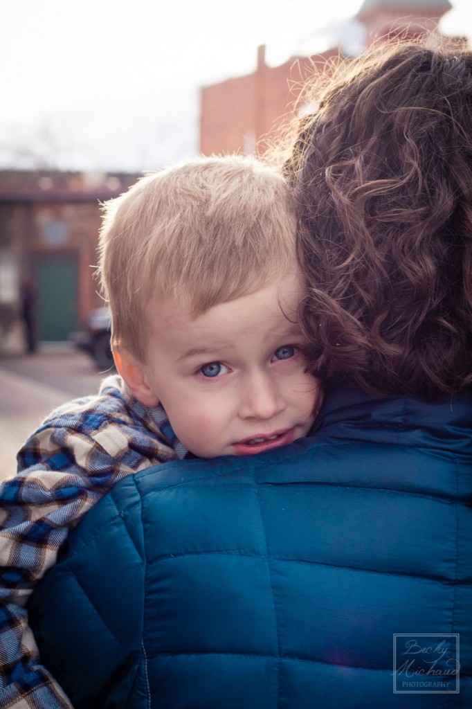 LIttle boy with deep blue eyes hugging his mother