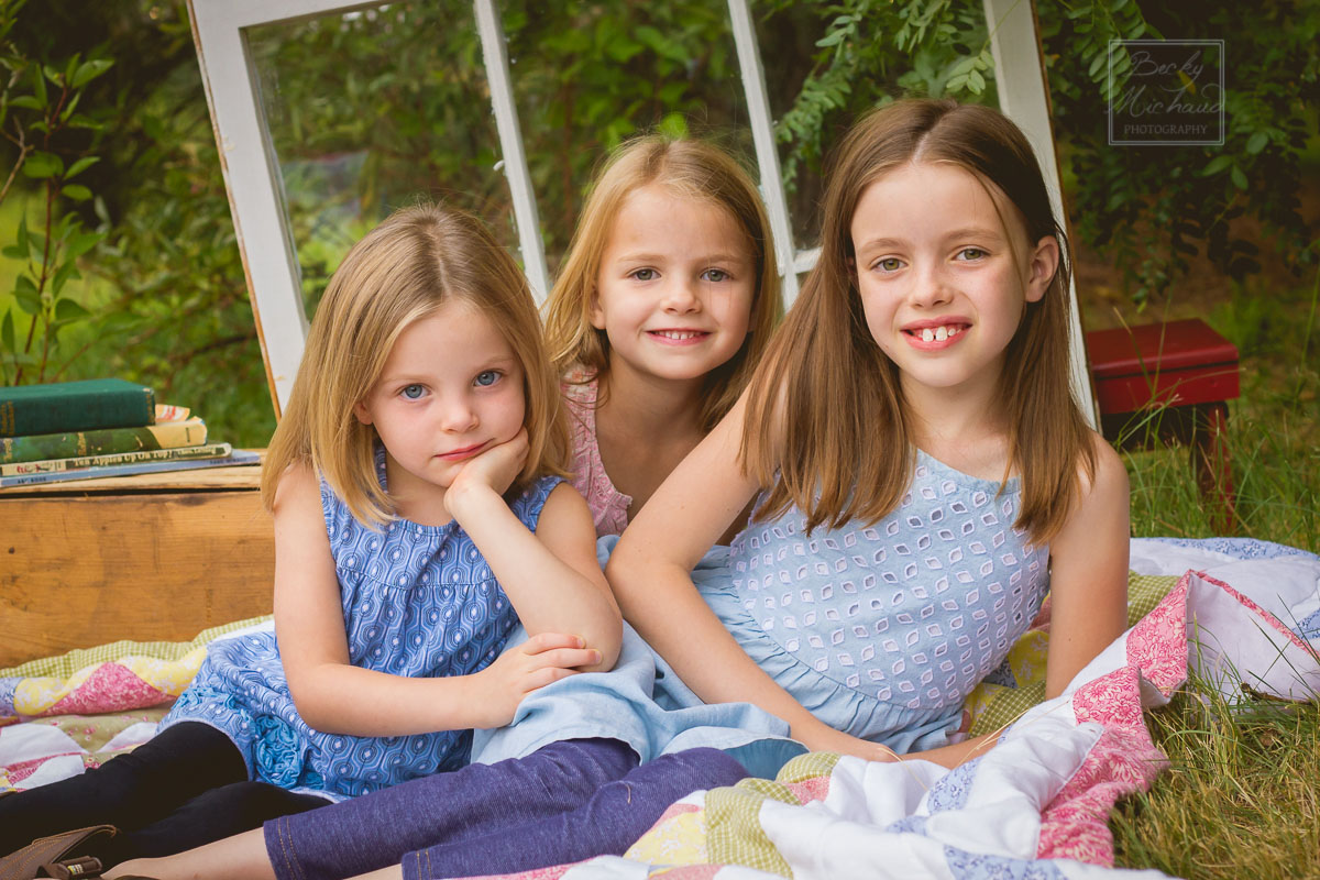 Portrait of three girls on a blanket with vintage props 