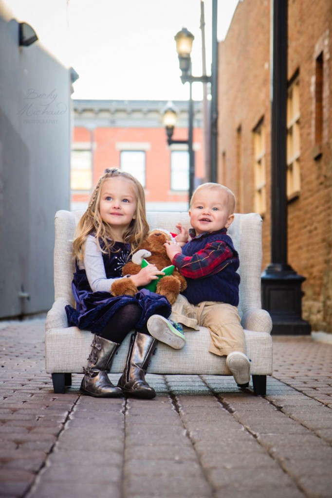 kids on a couch with a Christmas bear in an alley in Fort Collins Old Town