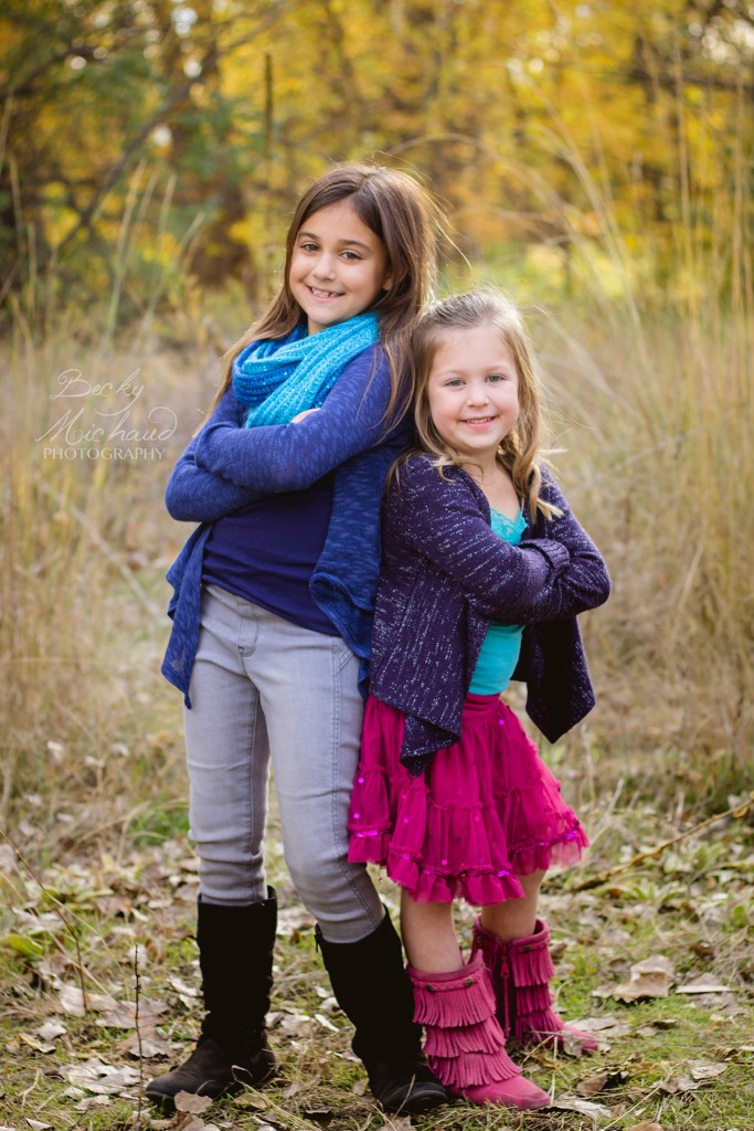 Sisters posing in front of fall leaves in north fort collins