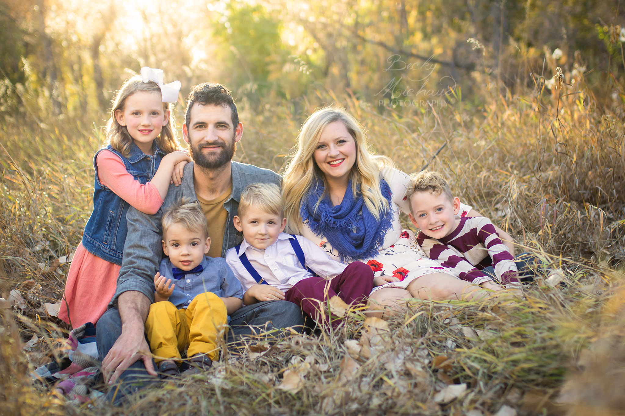 A family of six poses in a field at a Fort COllins Natural Area for a portrait by Becky Michaud, Family Photographer