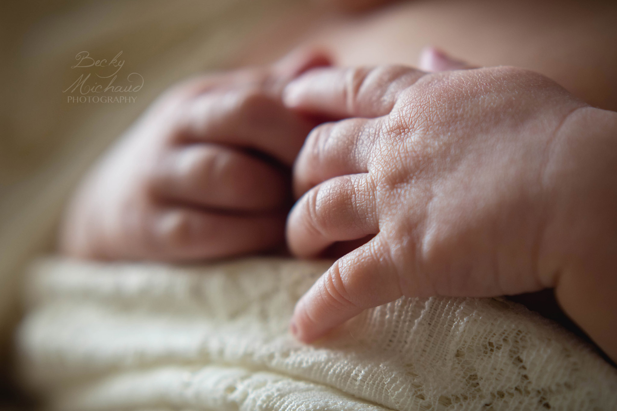 close up of newborn's hands folded together