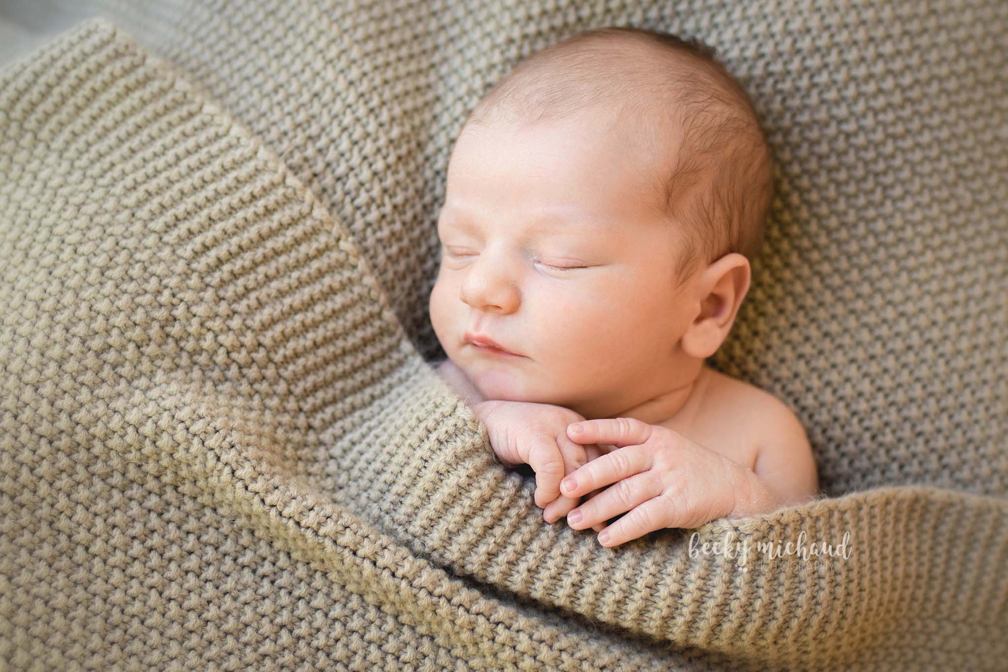 newborn photography tucked in pose with a tan blanket