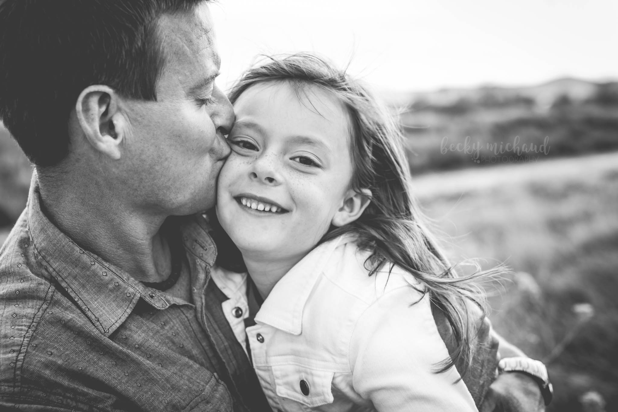 black and white photo of a dad kissing his daughter taken by Becky Michaud, Northern Colorado photographer