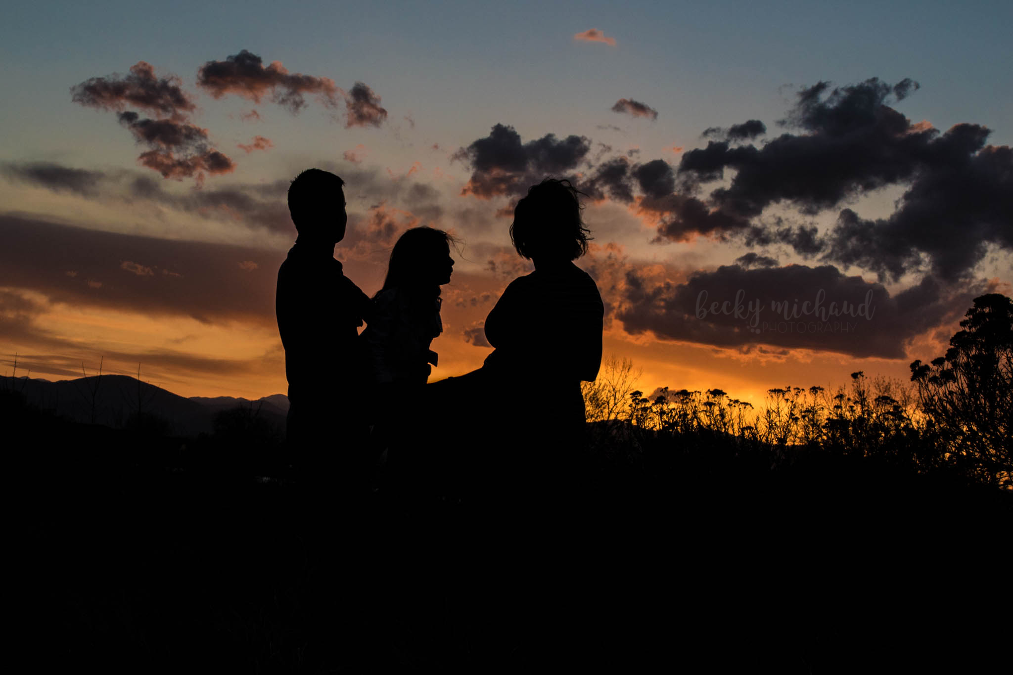 silhouette of a family of three at sunset over Equalizer Lake in Loveland, Colorado