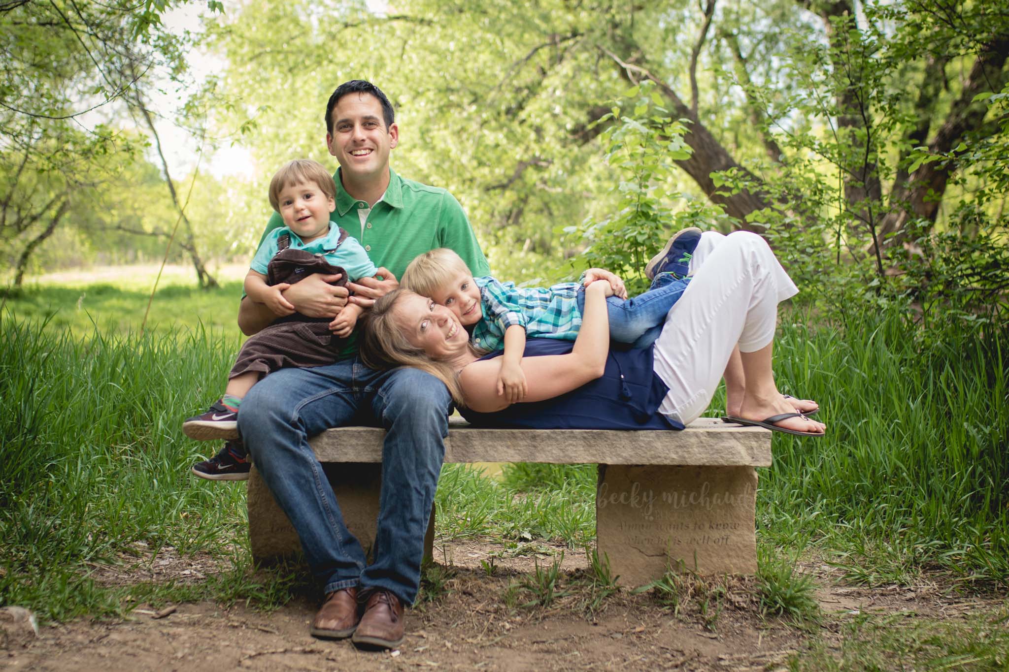 A family sitting on a bench together at Lee Martinez Park in Fort Collins