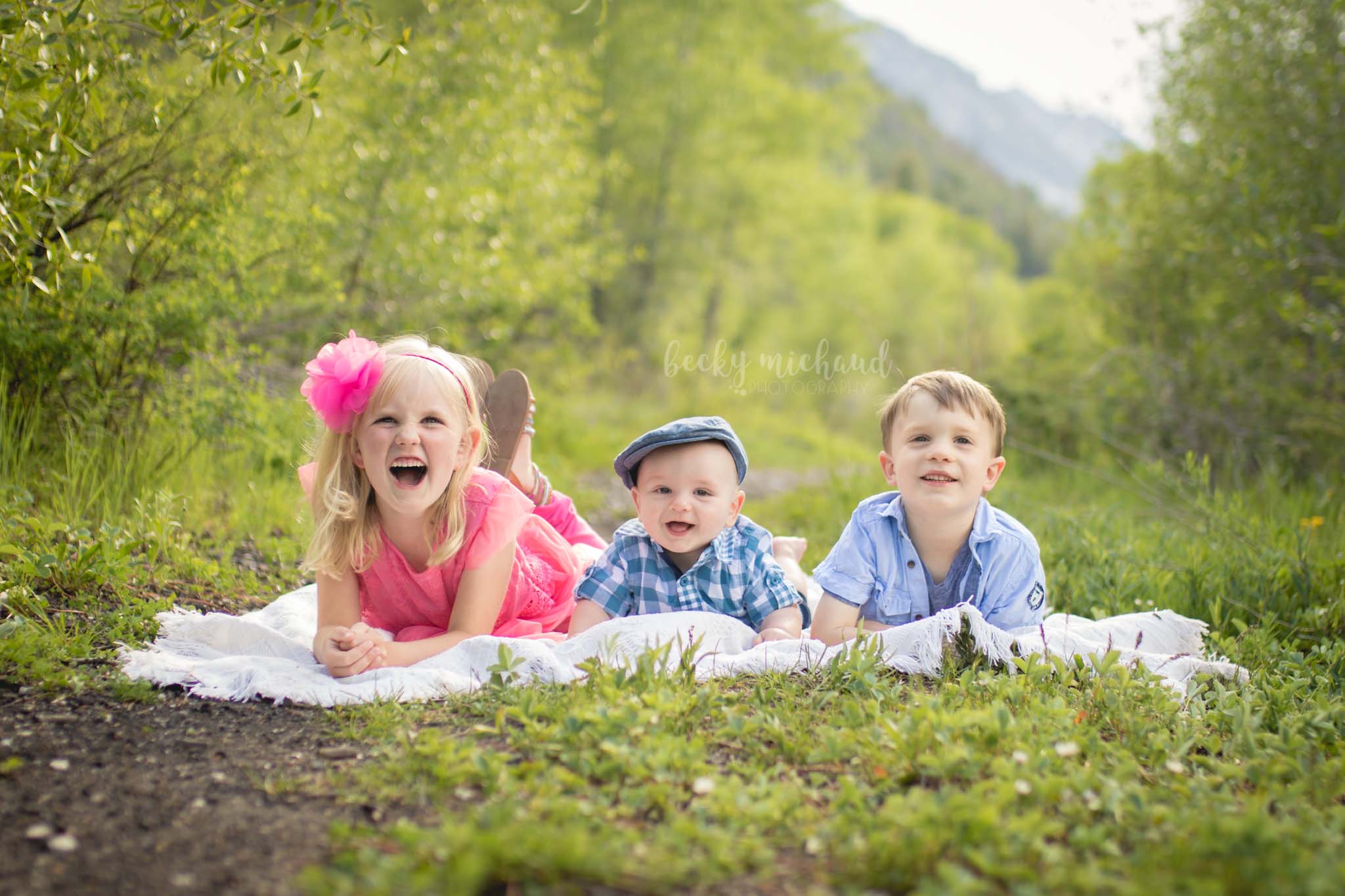 Three siblings on a blanket in the Colorado mountains