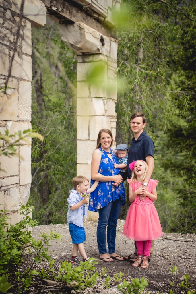 A family poses by a wall from the old mill site in Marble, Colorado