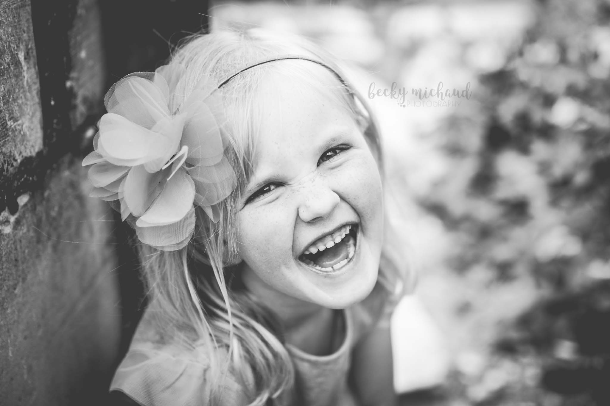 black and white portrait of a girl laughing taken by Becky Michaud, child photographer in Colorado