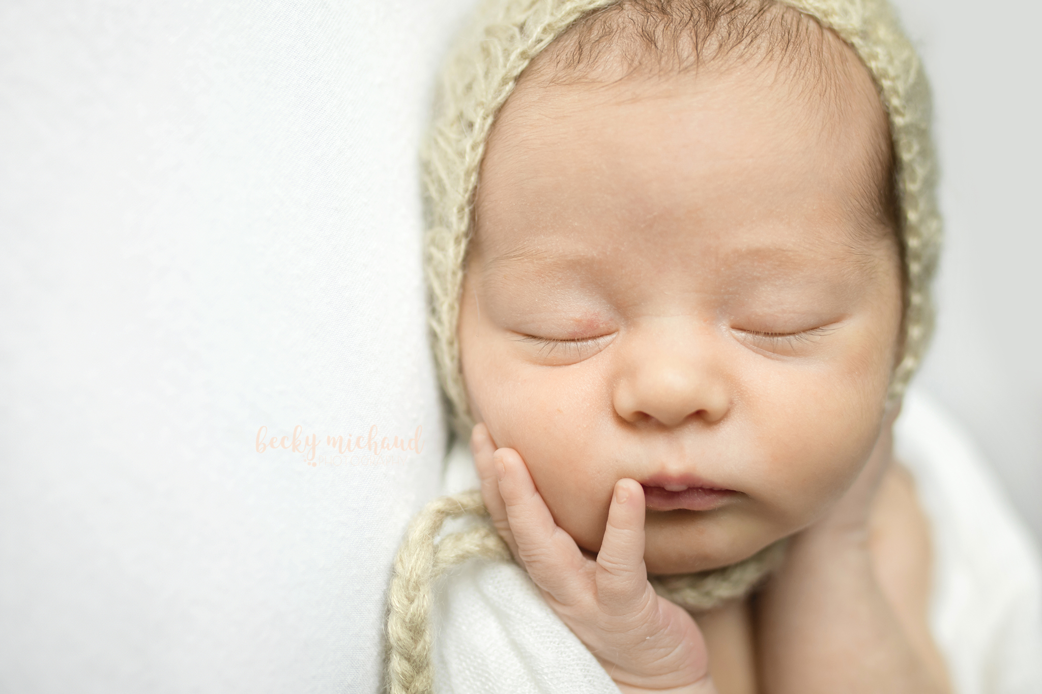 close up photo of a newborn girl touching her face