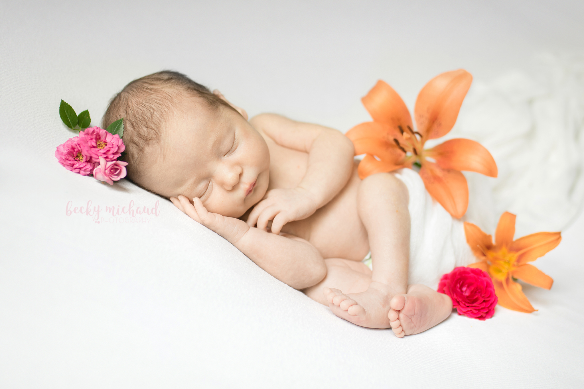 Newborn girl posed with bright flowers