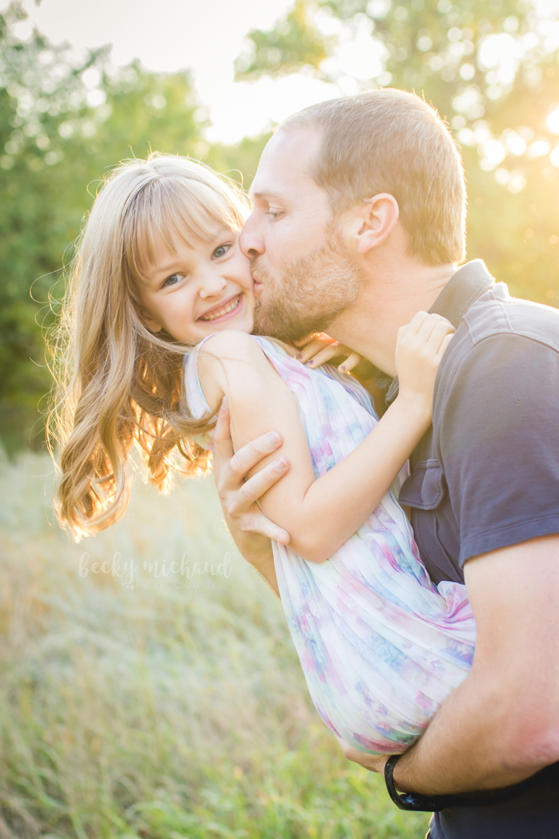 A dad kisses his daughter during their family photo session with Becky Michaud, Fort Collins photographer