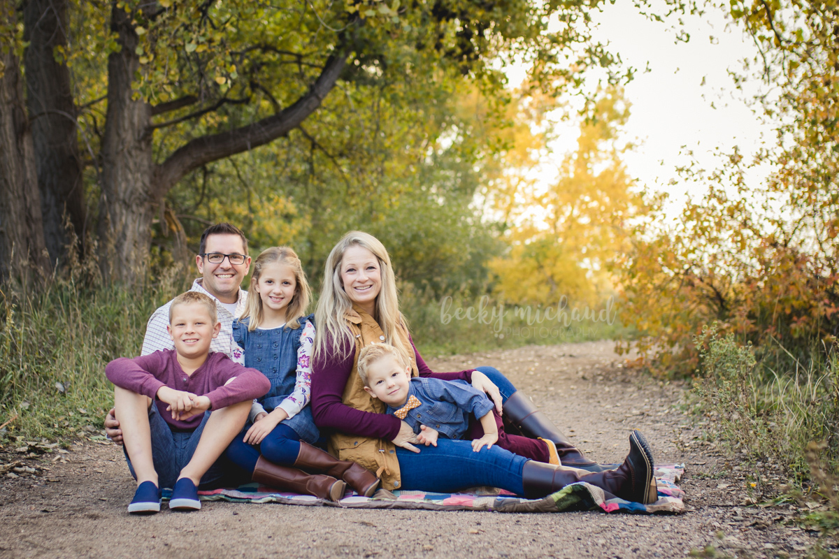 A family of five poses in fall leaves for their Fort Collins photo session
