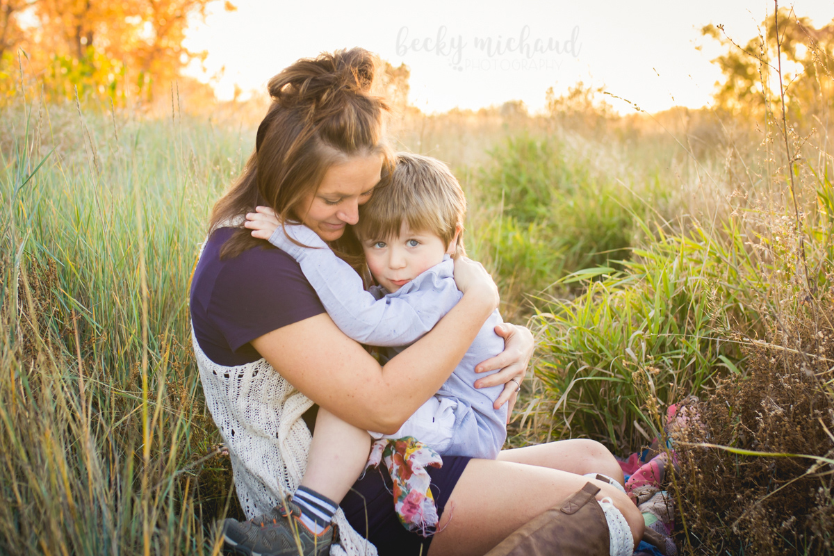 A mom holds her little boy in a field in the fall in Colorado