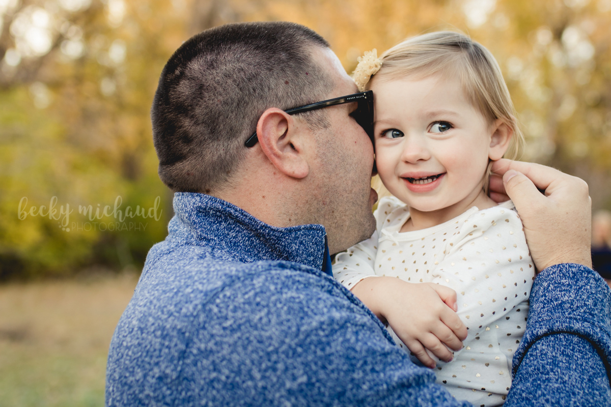During a photo session with Becky Michaud, Colorado photographer, a dad whispers a secret in his little girl's ear