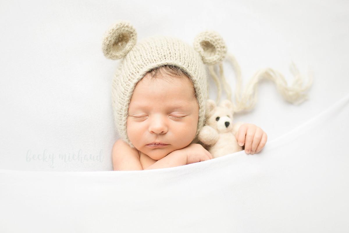 Newborn baby wearing a bear hat and holding a felted wool bear during his photo session with Becky Michaud, Fort Collins newborn photographer
