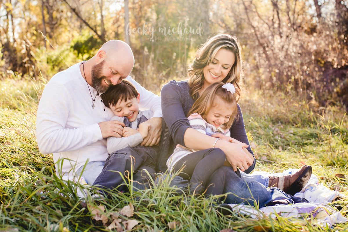 Parents tickle their kids during their family photo session in Fort Collins, Colorado