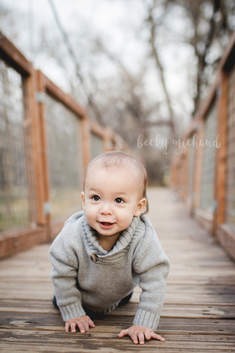 Baby boy crawling on a wooden bridge at the Poudre Environmental Learning Center