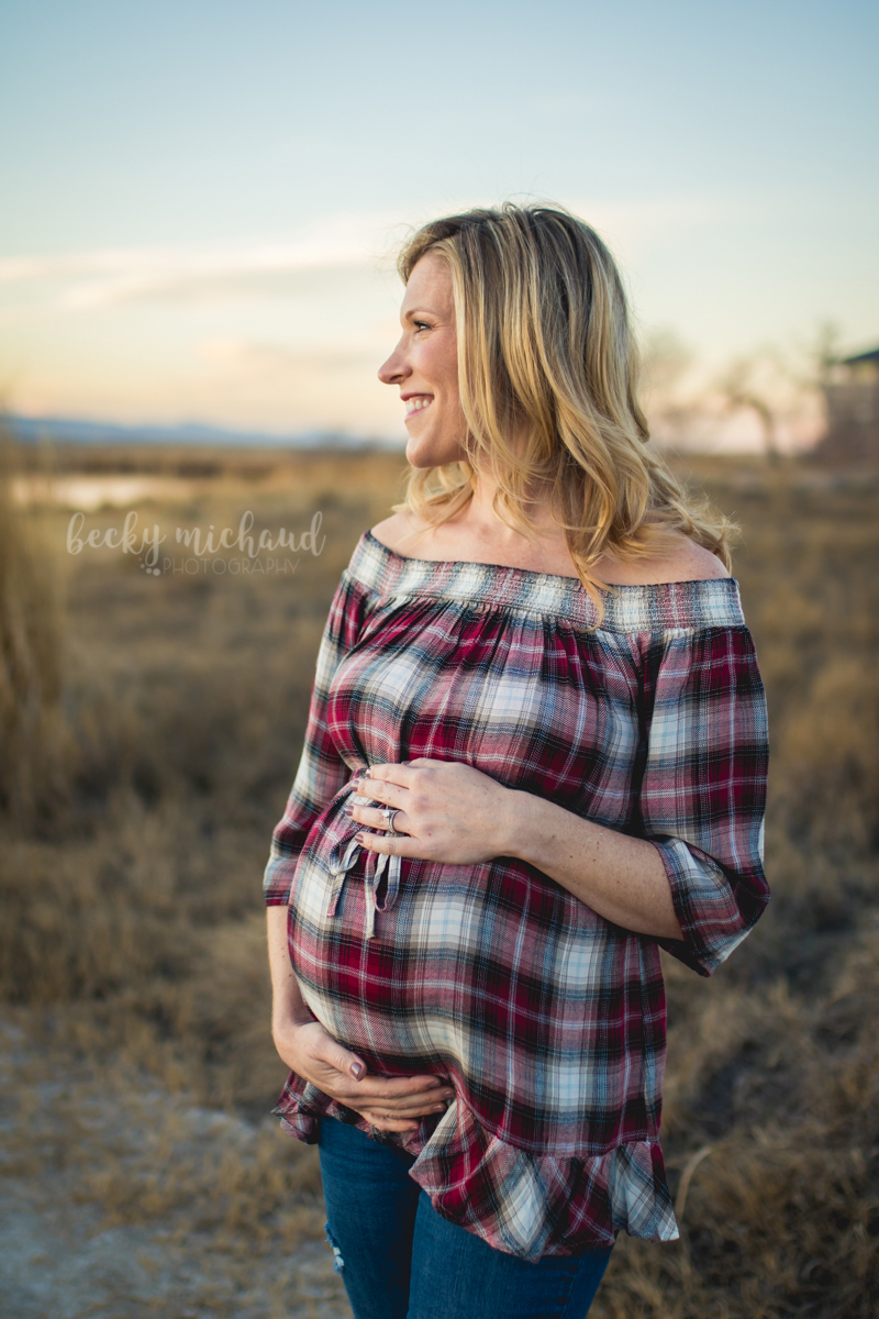 A mama-to-be gazes at the sunset during her Northern Colorado maternity photo session