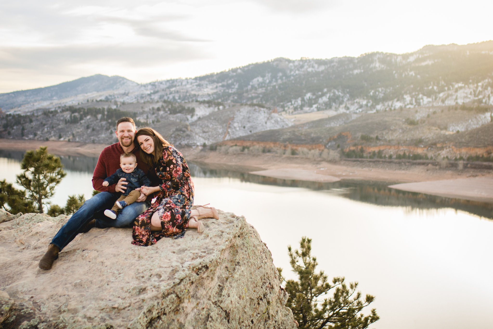 A family of three sits on a rock overlooking beautiful Horsetooth Reservoir in Fort Collins, CO