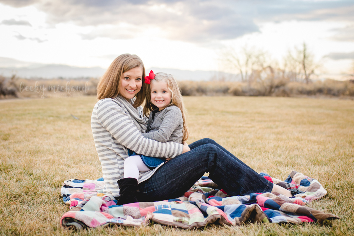 Colorado photo with a mom snuggling with her little girl on a blanket in a field