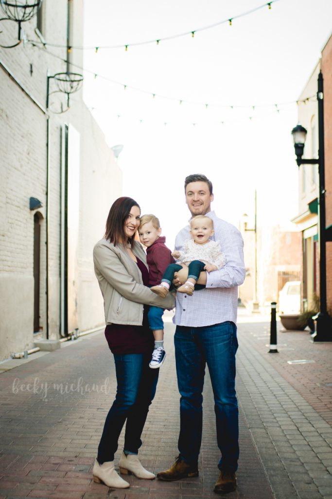 In Old Town Fort Collins, a family poses in the middle of firehouse alley for their winter family portrait session