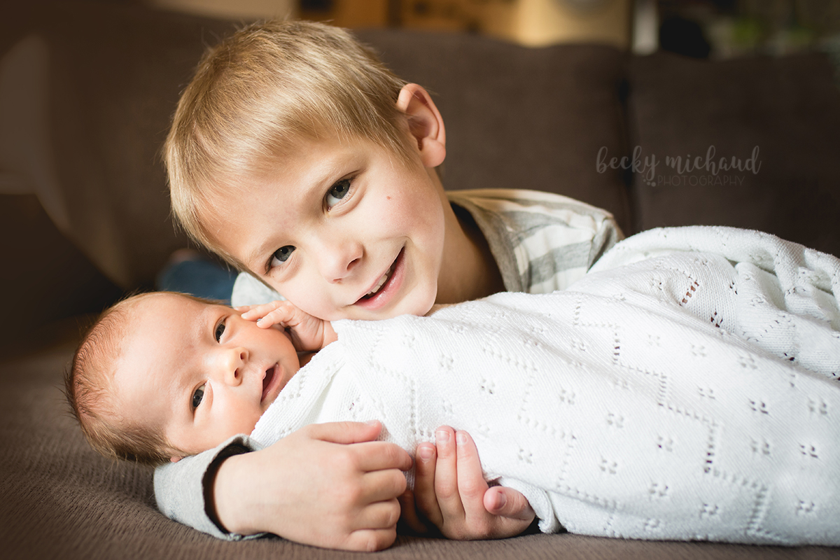Lifestyle newborn portrait of two brothers on their couch in their home in Windsor, Colorado