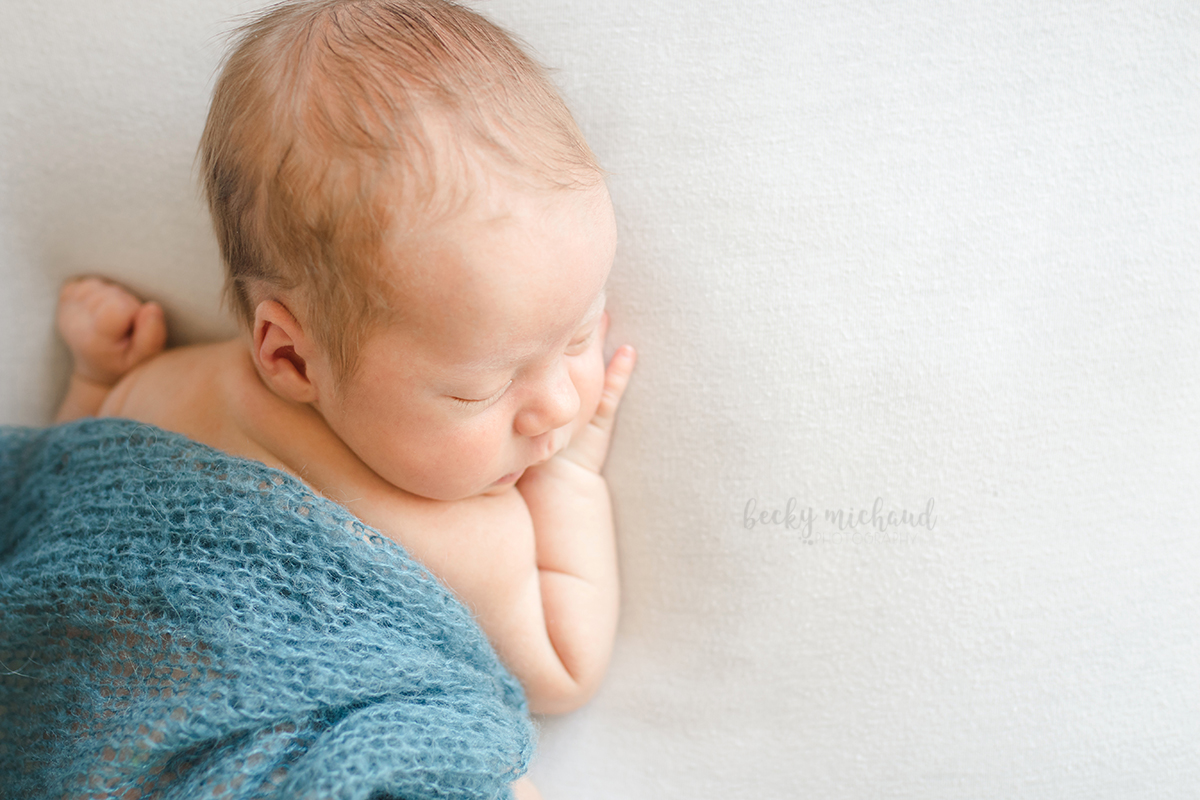 Organic, natural newborn portrait of a baby boy under a blue blanket