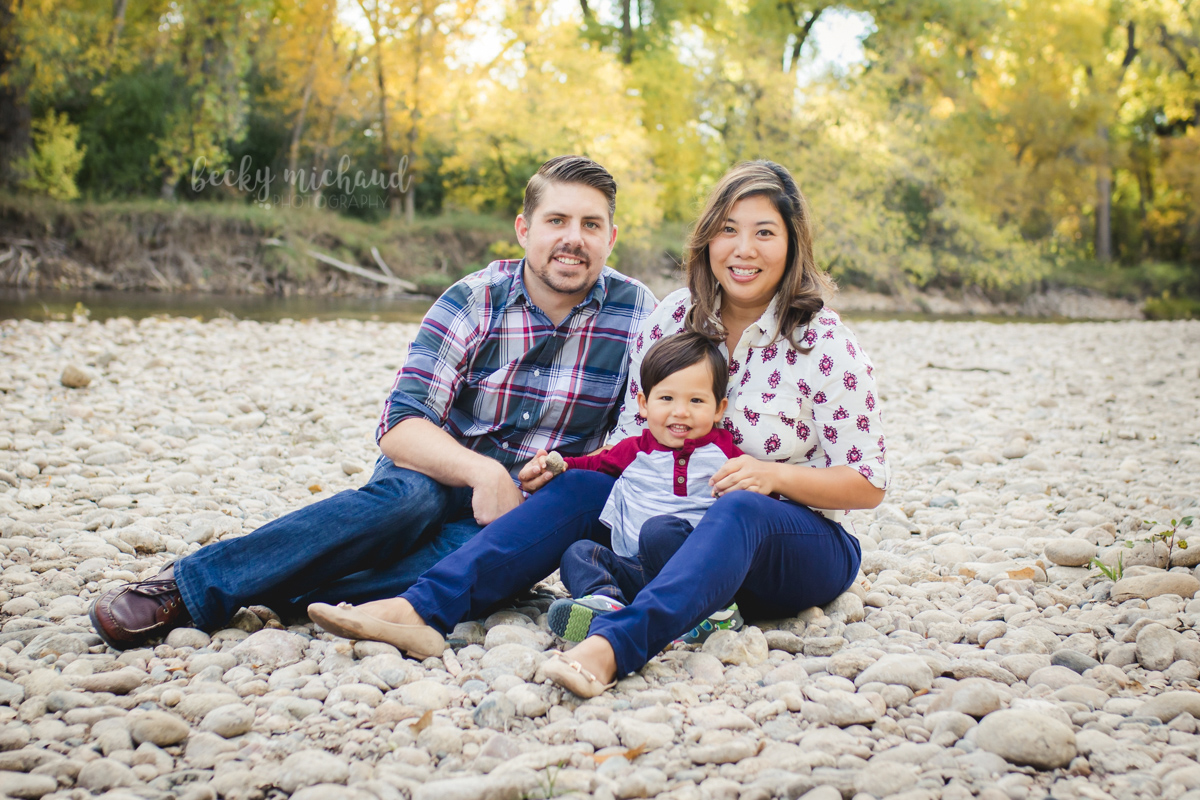 A family poses by the Poudre River in Fort Collins during their family photo session