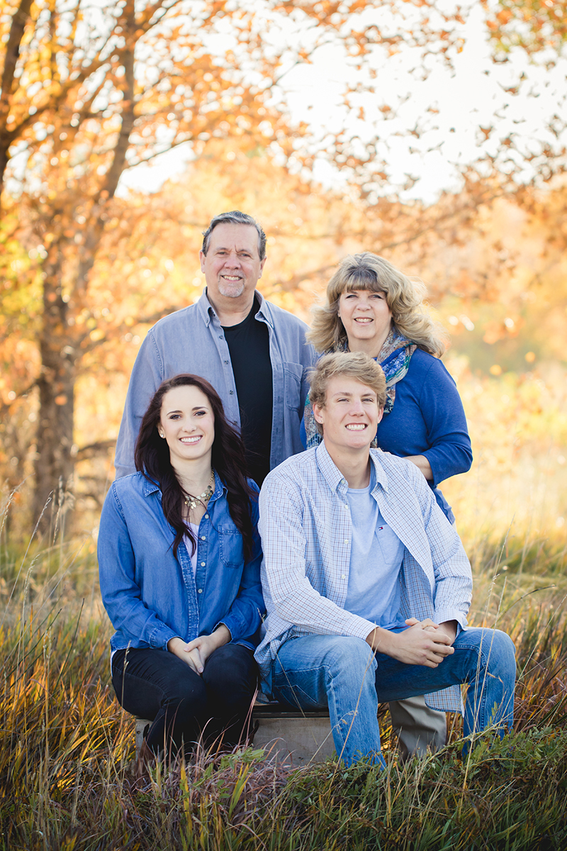 A family poses by the yellow fall leaves at Arapahoe Bend Natural Area in Colorado