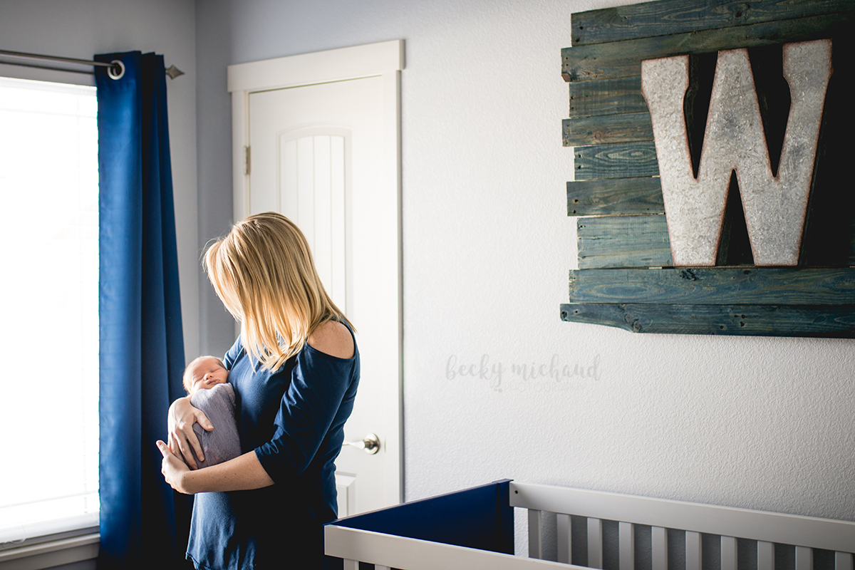 Lifestyle newborn photo of a new mom holding her baby in their Eaton, Colorado home in his nursery