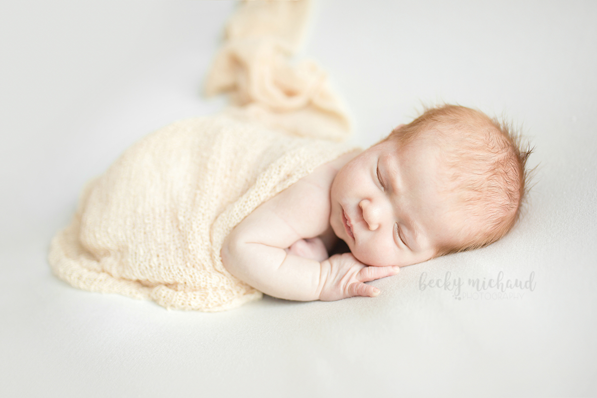 Simple, organic newborn portrait on a white backdrop