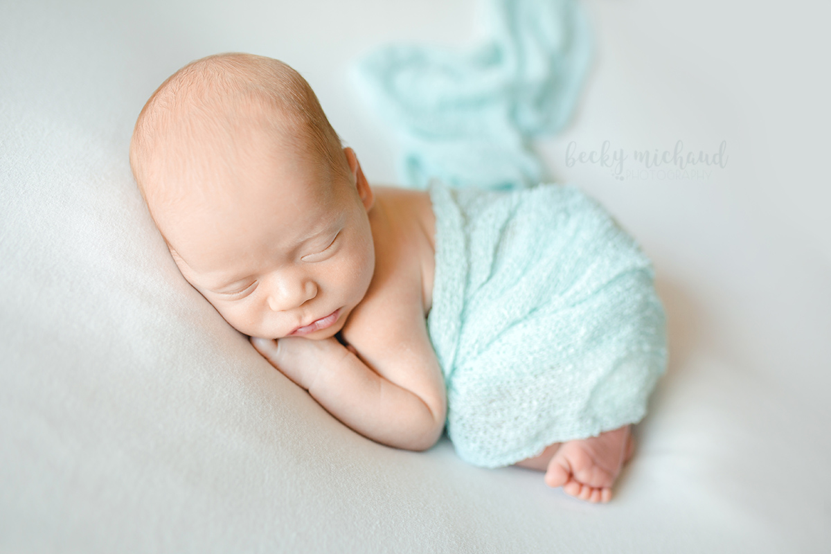 Simple newborn portrait of a baby boy with a blue blanket taken in Timnath, Colorado