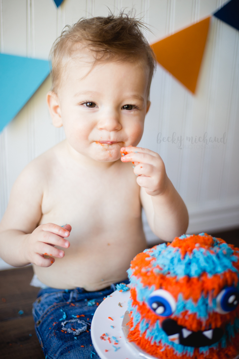 A Fort Collins one year old enjoys his first taste of cake during his cake smash photo session