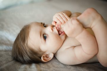 Lifestyle photo taken by Becky Michaud in Northern Colorado of a baby boy chewing on his toes