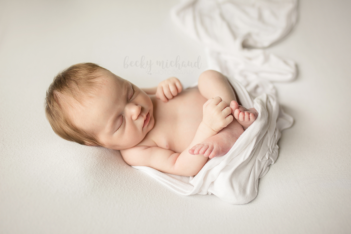 Simple natural newborn photo of a baby on a white blanket in Fort Collins, Colorado