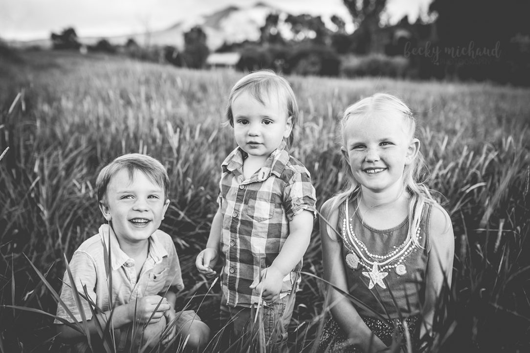 Black and white photo of three kids in a field taken by Becky Michaud, Fort Collins Photographer