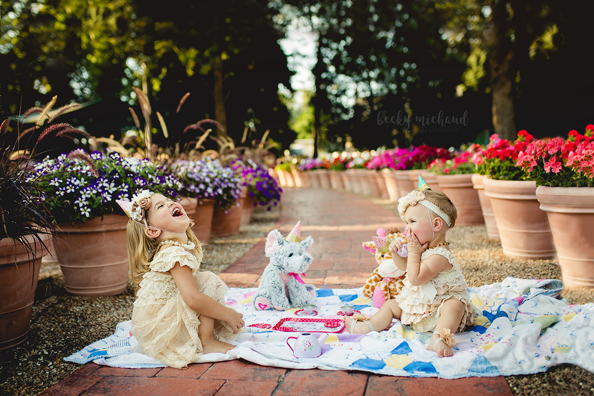 Two little girls having a tea party in a flower garden in Fort Collins Colorado
