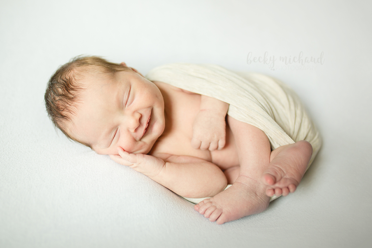 Simple organic photo of a smiling newborn taken in baby's Fort Collins Colorado home