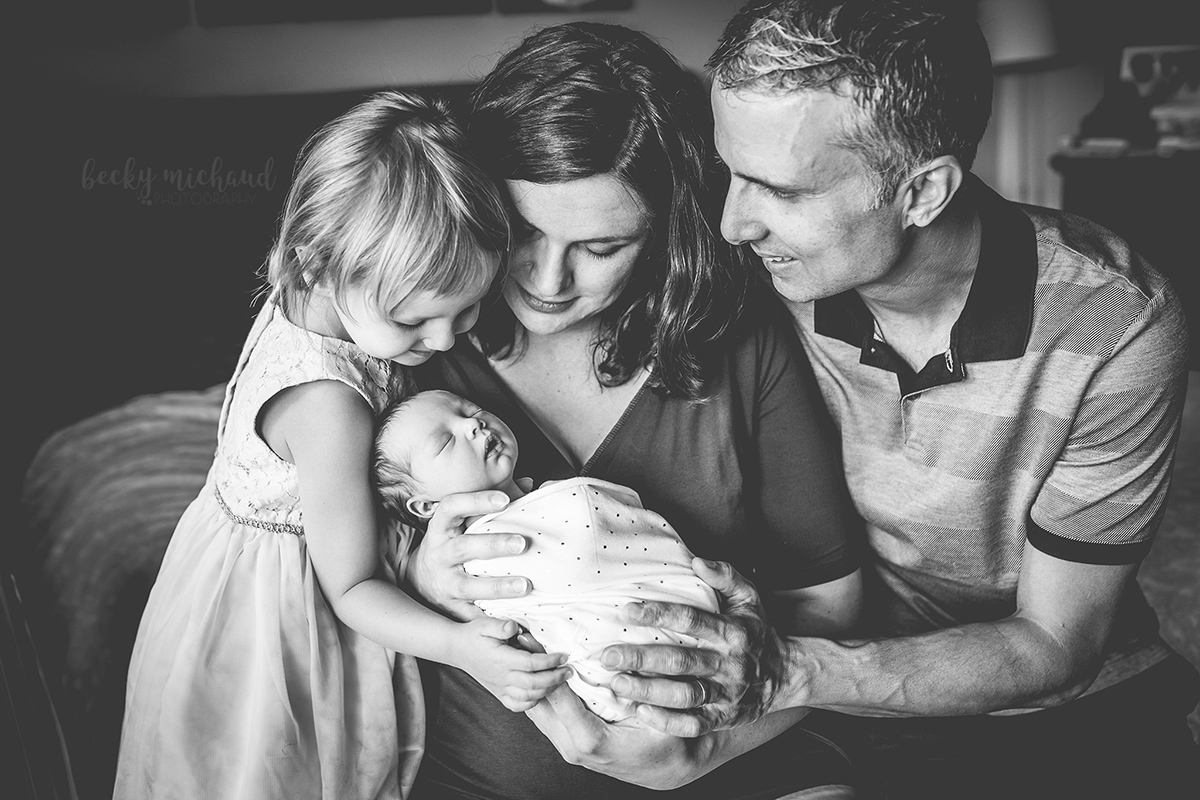 Black and white portrait of a family of four during their lifestyle newborn session in their Colorado home