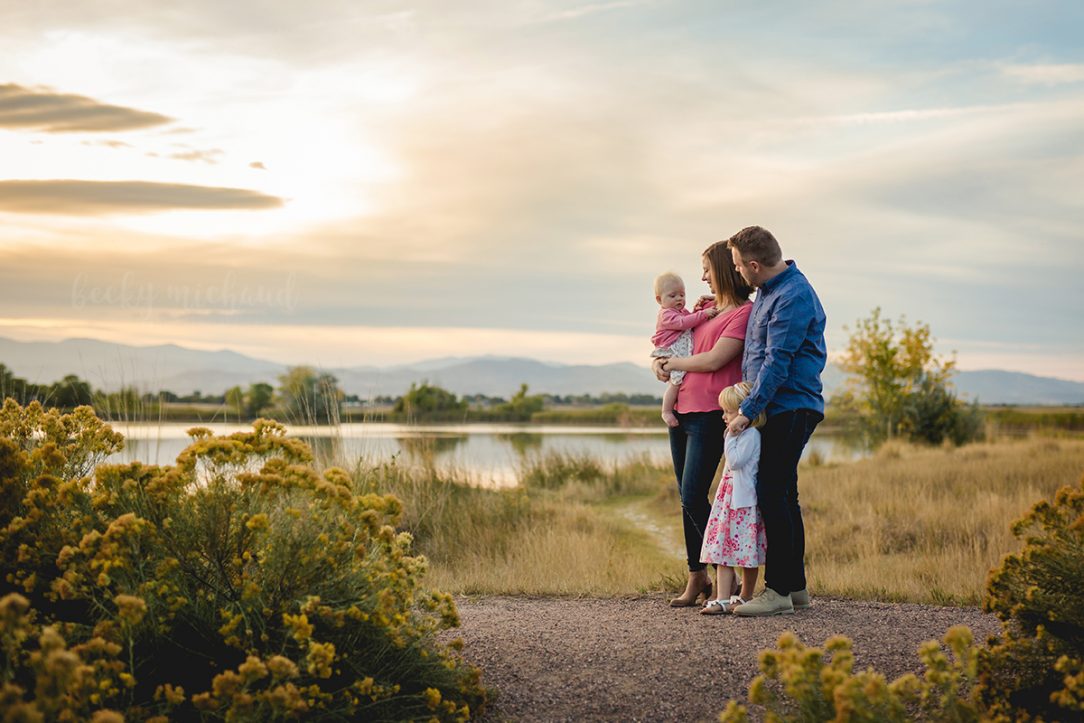 A family of four watches the sunset during their Northern Colorado family photo session