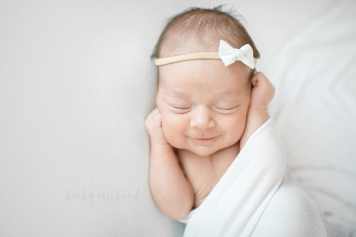 Simple, timeless photo of a baby girl on white taken during her in home newborn photo session in Fort Collins