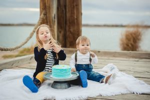 Big sister gets to join in the fun during her brother's cake smash photo shoot in Northern Colorado