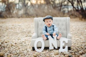 A baby boy in a one year old milestone photoshoot taken at a Fort Collins natural area