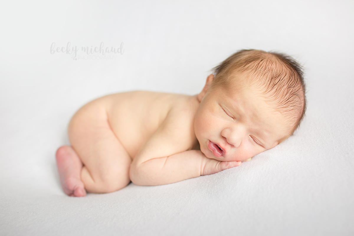 Simple organic photo of a newborn baby on a white backdrop taken in Fort Collins Colorado