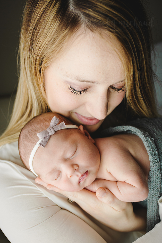 A new mom gazes at her beautiful baby girl during their Loveland, Colorado in home newborn photography session