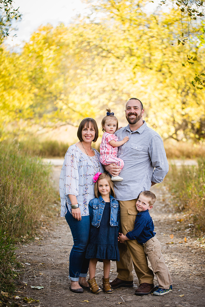 The yellow fall leaves provide a beautiful backdrop for the family of five's Fort Collins photography session