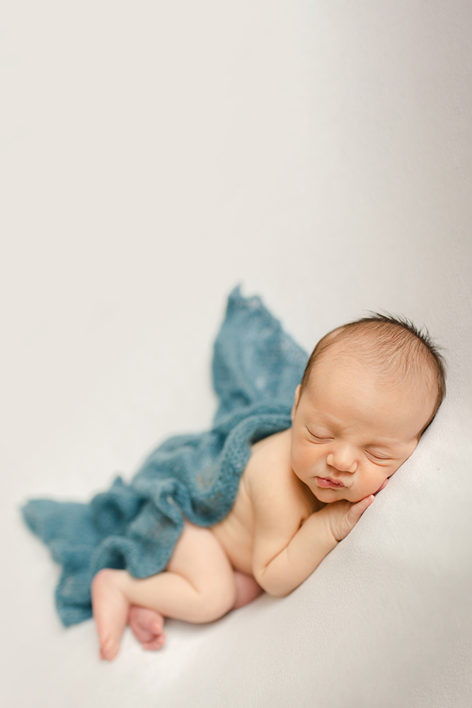 Simple newborn photo of a baby boy with a blue blanket taken by Becky Michaud, Fort Collins newborn photographer