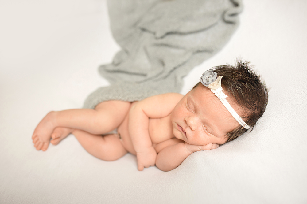 Simple newborn photo of a baby girl in gray taken in her Fort Collins Colorado home