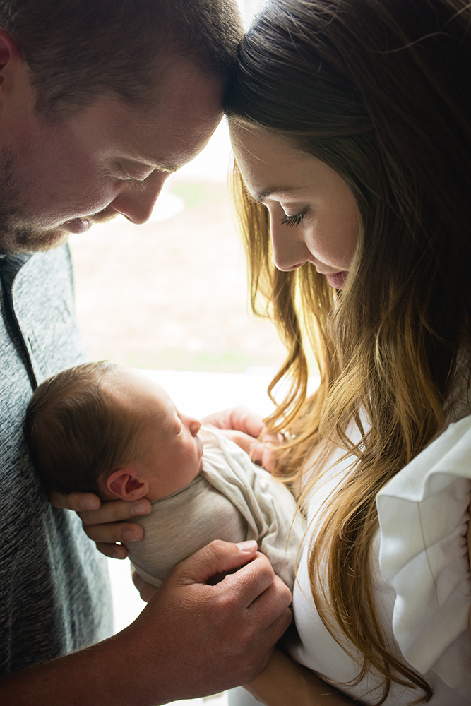 mom and dad admire their new baby boy during their in home newborn photo shoot